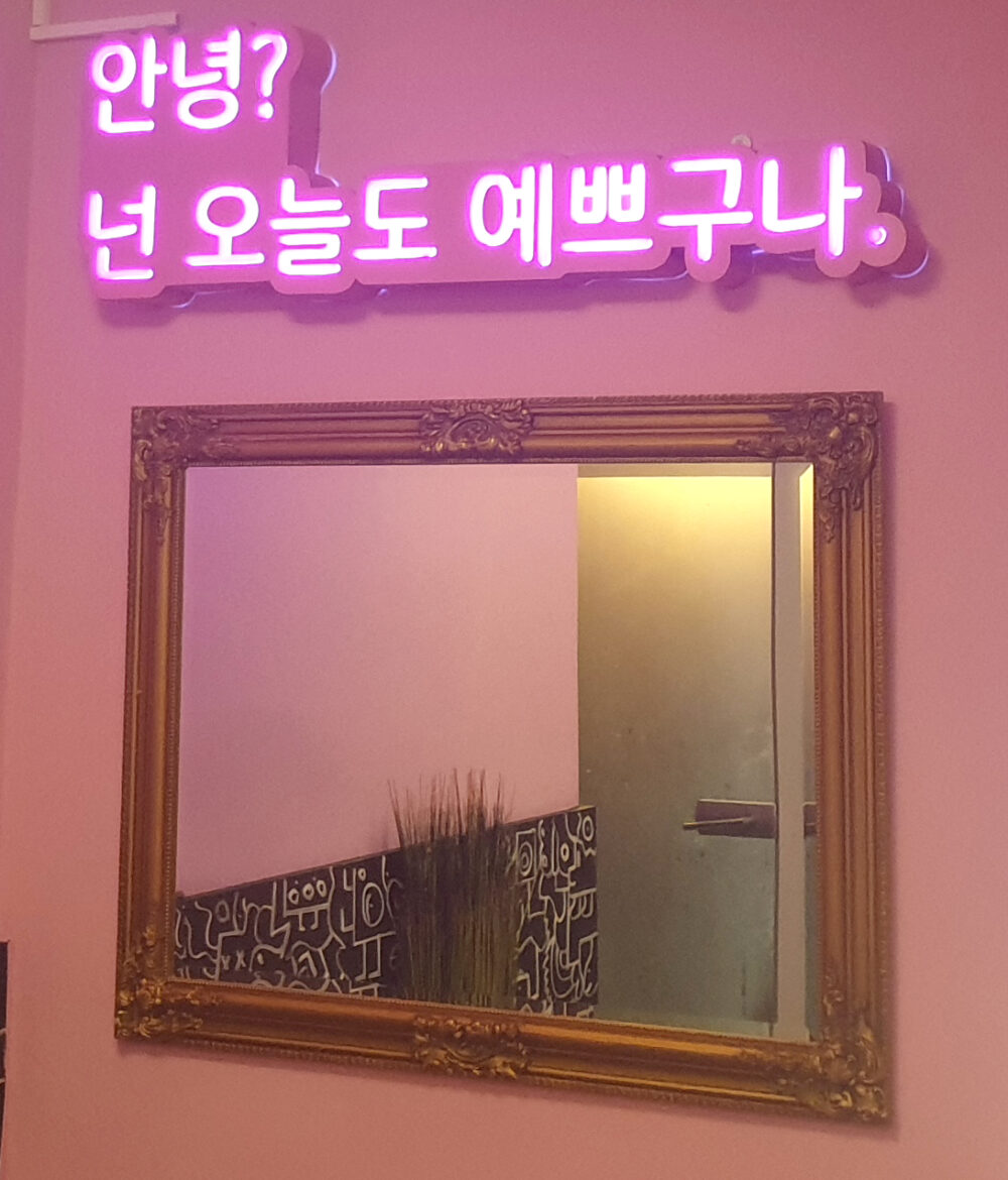 Spiegel mit oben drüber Leuchtschrift in koreanischen Buchstaben