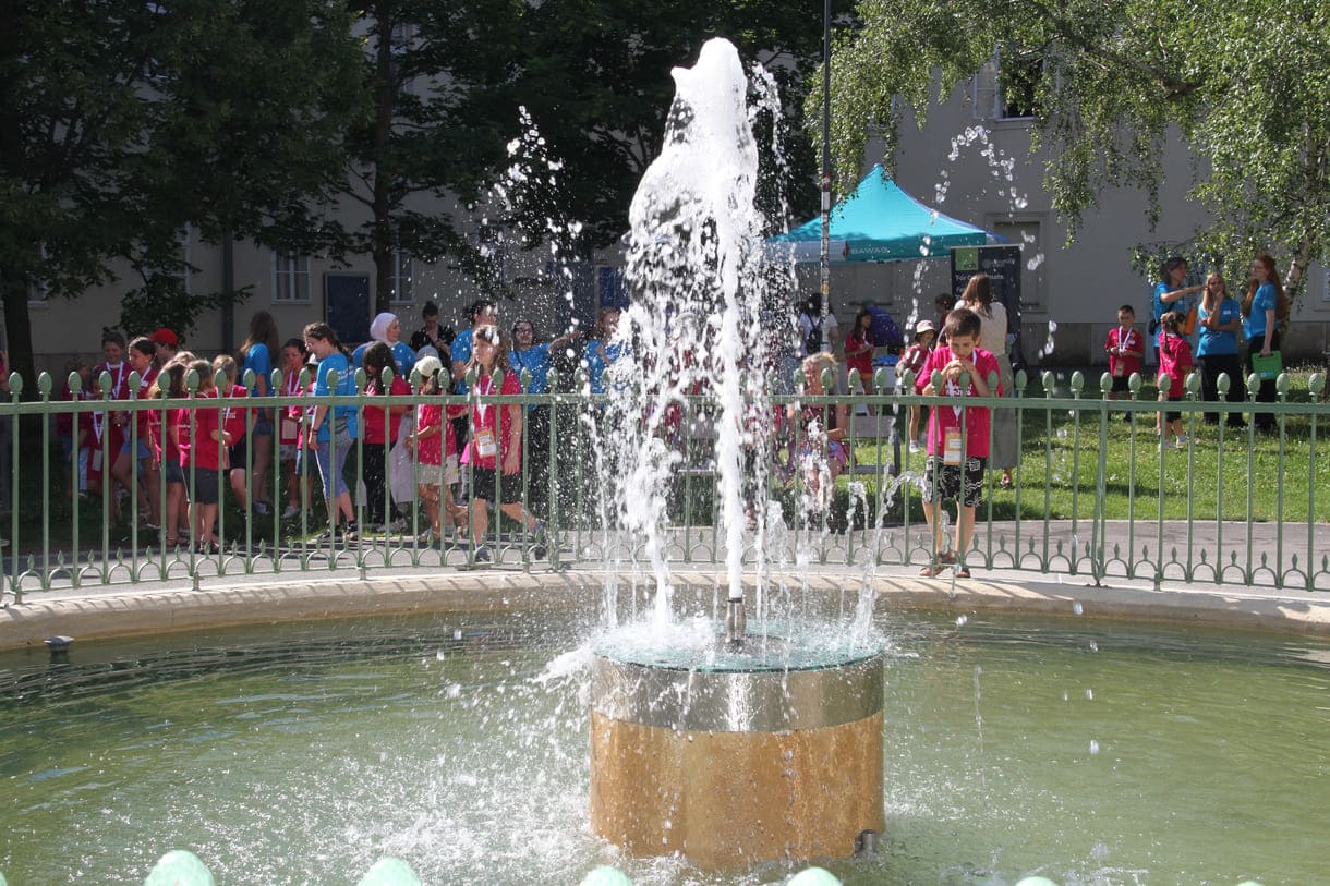 Kinder beim Springbrunnn in der Mitte des Uni-Campus-Hofes