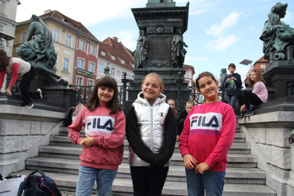 KinderParlamentarier:innen auf den Denkmal-Stufen am Grazer Hauptplatz