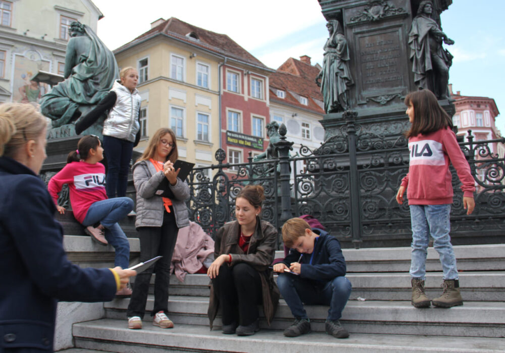 KinderParlamentarier:innen auf den Denkmal-Stufen am Grazer Hauptplatz