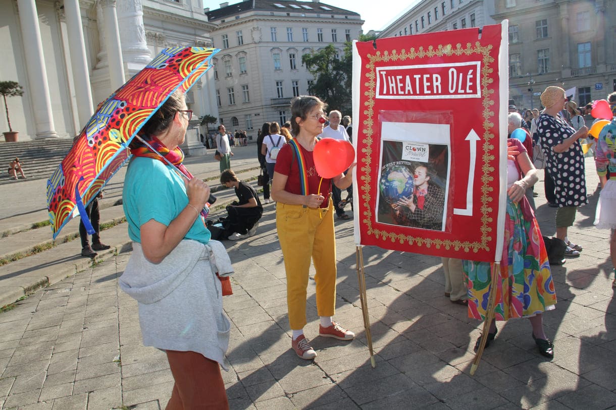 Großes rote Tafel des Clowntheaters Olé, das die Kundgebung organisiert hatte