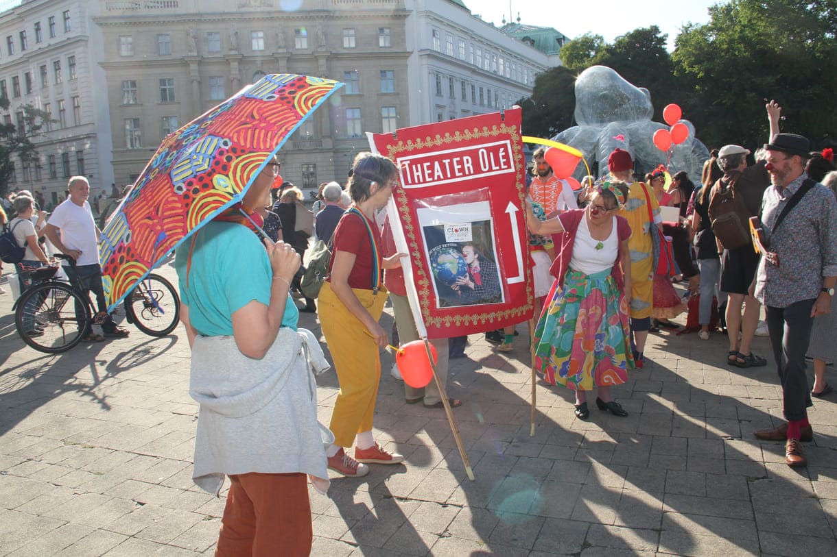 Großes rote Tafel des Clowntheaters Olé, das die Kundgebung organisiert hatte