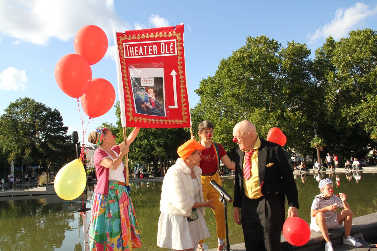 Großes rote Tafel des Clowntheaters Olé, das die Kundgebung organisiert hatte