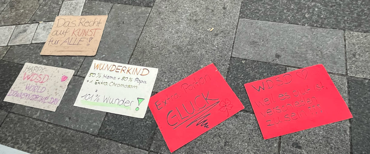 Karton-Tafeln mit handschriftlichen Sprüchen zum Welt-Down-Syndrom-Tag