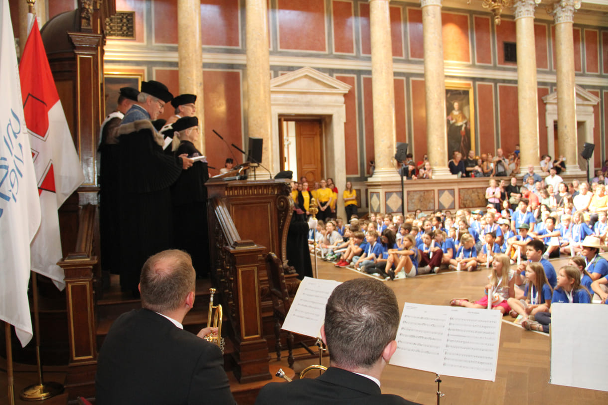 Würdenträger:innen der beteiligten Universitäten in ihren traditionellen Talaren