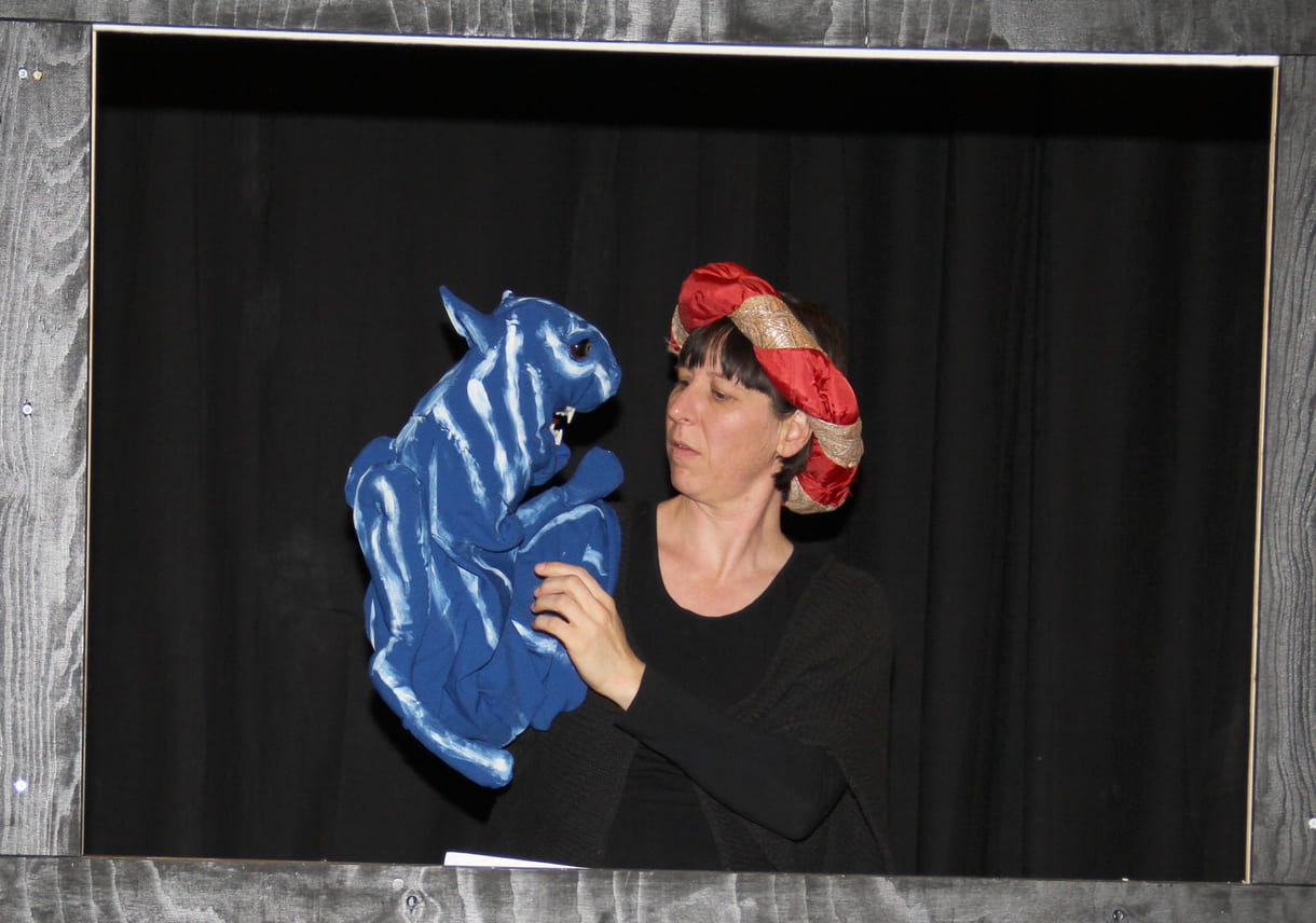 Die Puppenspielerin als Färber Hakim mit blauem Tiger als Handpuppe