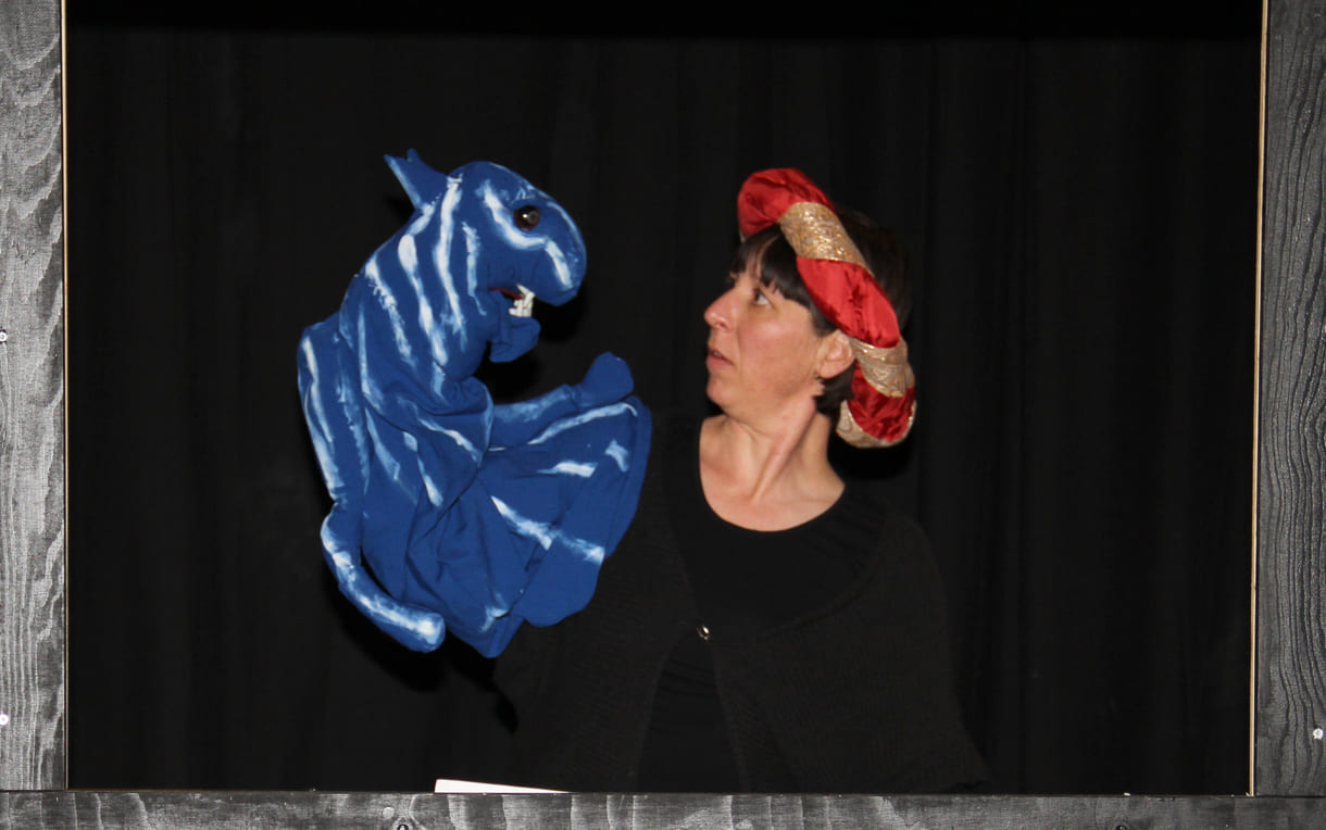 Die Puppenspielerin als Färber Hakim mit blauem Tiger als Handpuppe