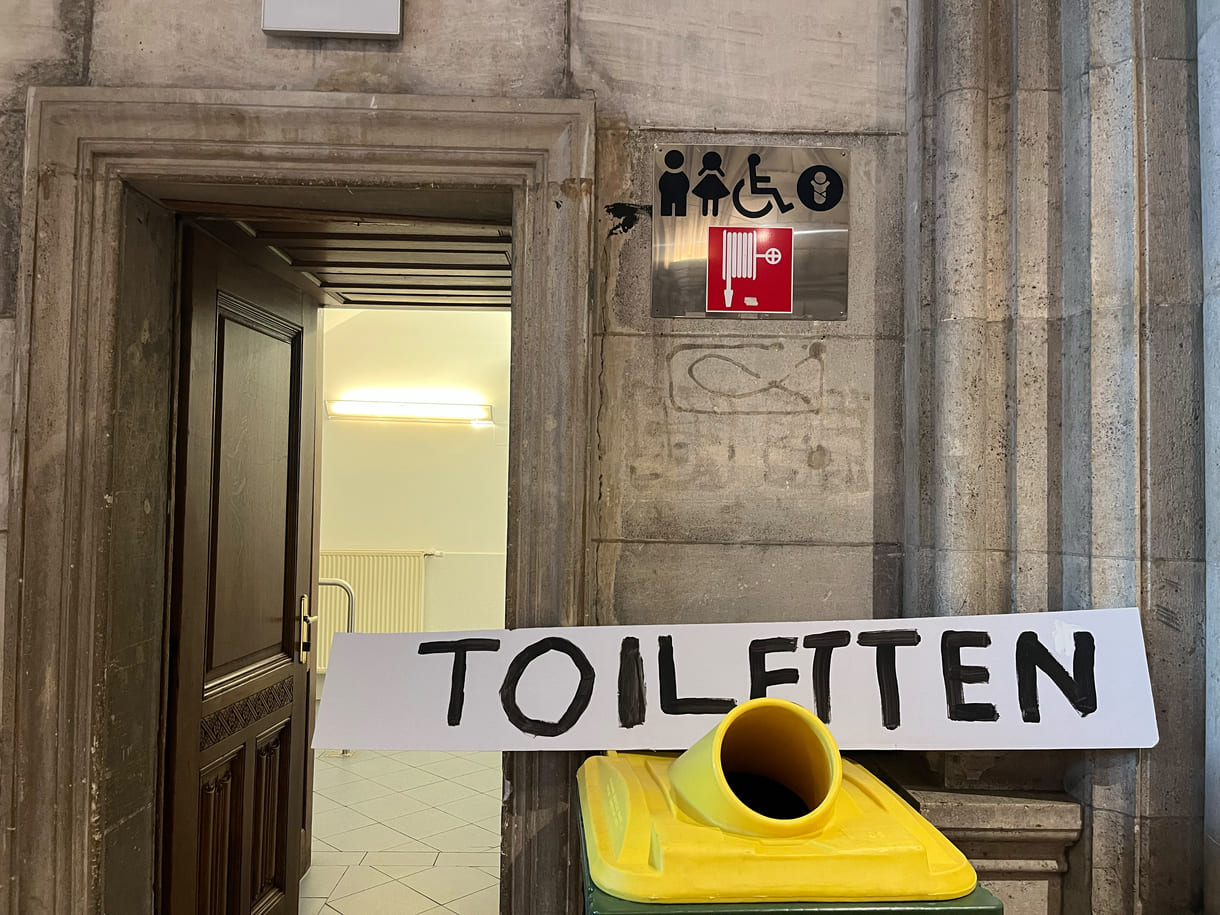 Auf Kinder-Augenhöhe das Schild zu den Klos