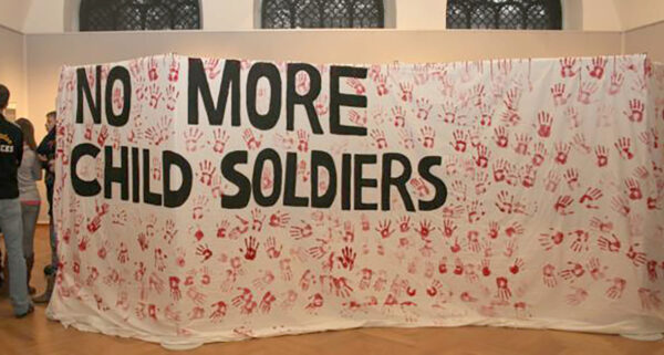 Transparent mit vielen "Red Hands" gegen Kindersoldat:innen-Zwang