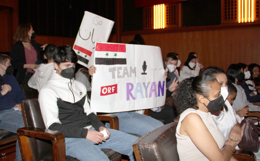 Starke moralische Unterstützung für ihre Mitschülerin im Finale, Rayan Alhasan Alhussein, durch mehrsprachige Transaprente