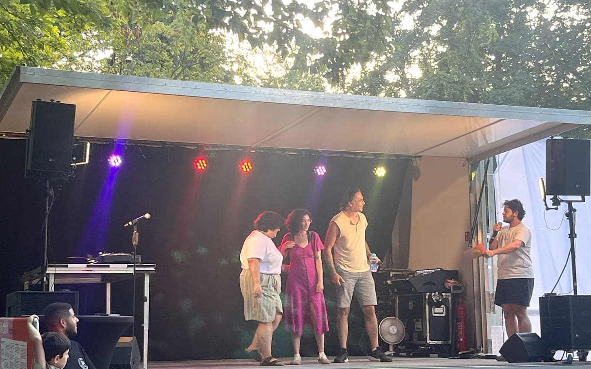 Drei Wiener Comedians mit syrischen Wurzeln am Ende auf der Bühne beim Applaus, moderiert von 