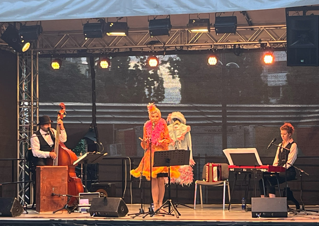 Eric Amelin, Susanne Leitnr alias Frau Eveline, und Stephanie Hacker auf der Kultursommer-Bühne im Meidlinger Wilhelmsdorfer Park