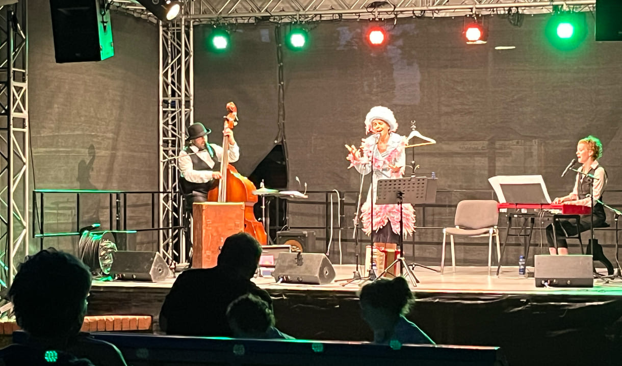 Eric Amelin, Susanne Leitnr alias Frau Eveline, und Stephanie Hacker auf der Kultursommer-Bühne im Meidlinger Wilhelmsdorfer Park