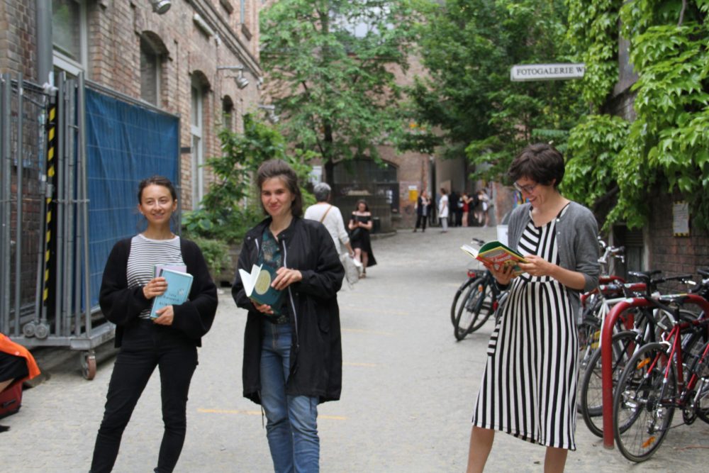 Drei junge Frauen mit Büchern stehen im WuK-Hof: Kathi Pech, Greta Egle und Sara Schausberger