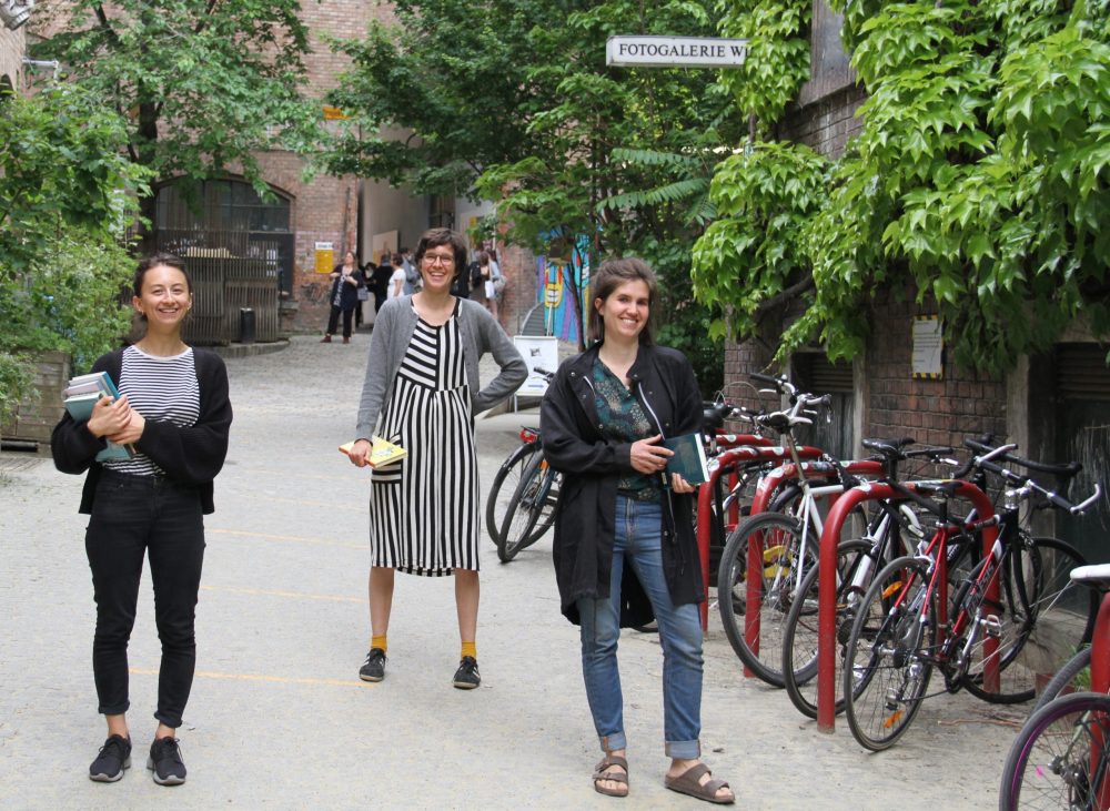 Drei junge Frauen mit Büchern stehen im WuK-Hof: Kathi Pech, Greta Egle und Sara Schausberger