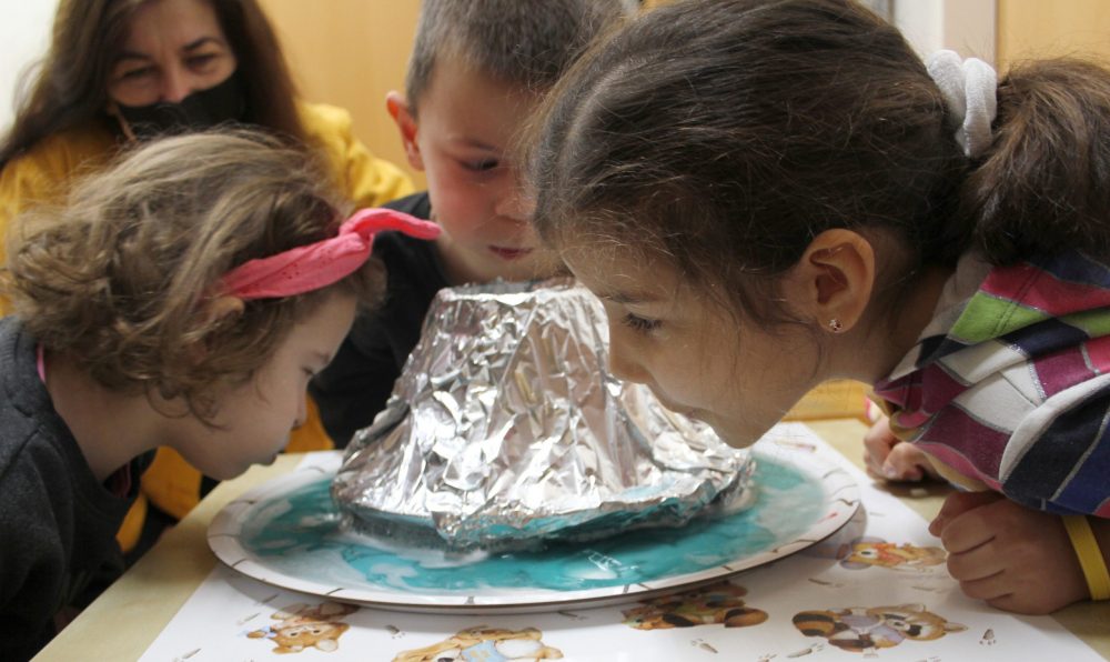 Kinder experimentieren und bauen einen Vulkan