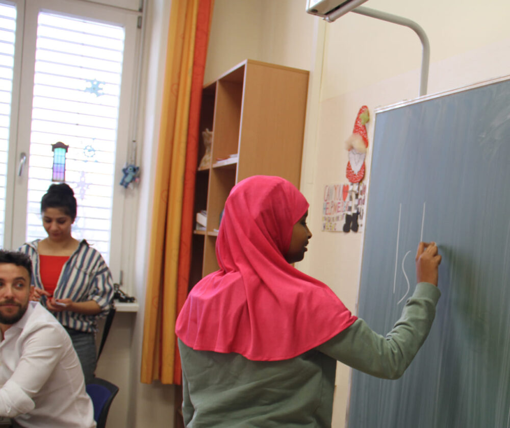 Undus schreibt das Somali-Wor für Schule an die Tafel