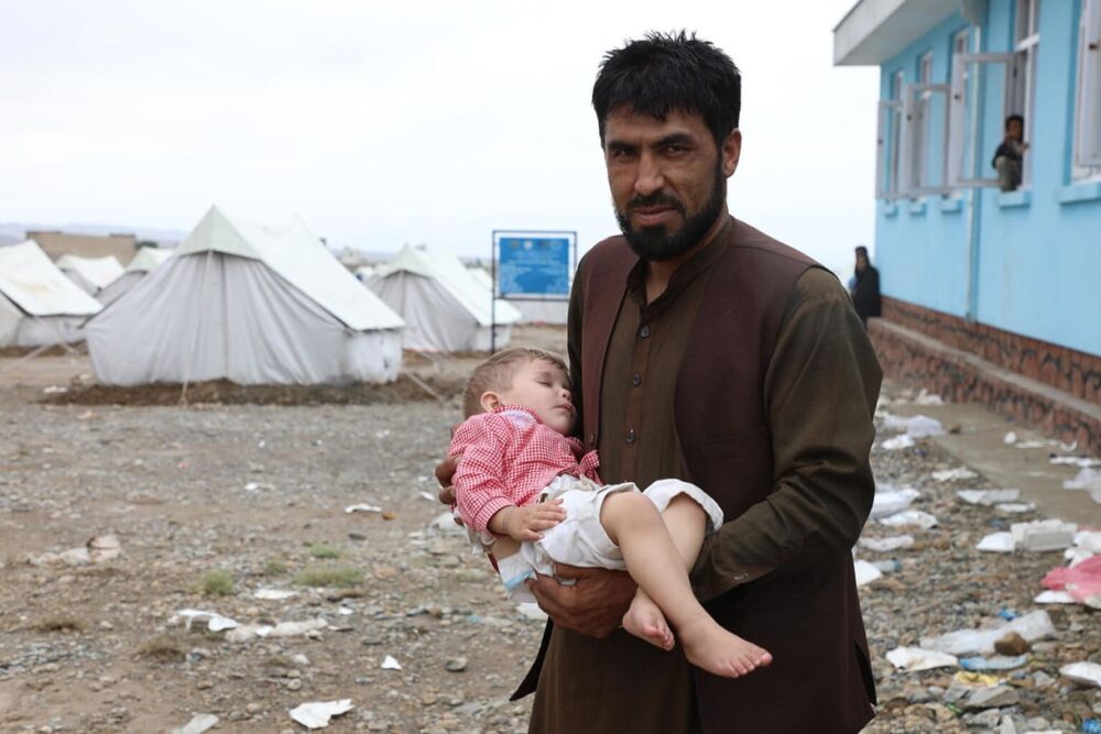 Am 24. August 2022 bringt ein Vater sein Kind zu einer von UNICEF unterstützten mobilen Gesundheitsklinik, um sich im Bezirk Khoshi, Provinz Logar, Afghanistan, behandeln zu lassen, wo sein Haus durch die jüngsten Überschwemmungen zerstört wurde.