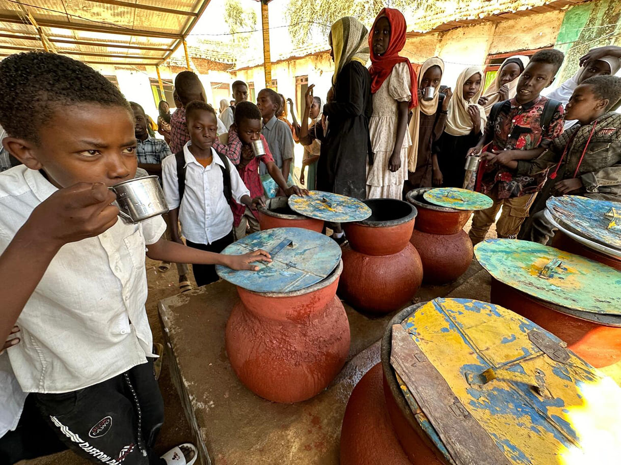 Am 5. Februar 2024 trinken Kinder der Al-Najah-Grundschule in der Stadt Zelingei in Zentral-Darfur, Sudan, in Tontöpfen aufbewahrtes Wasser.