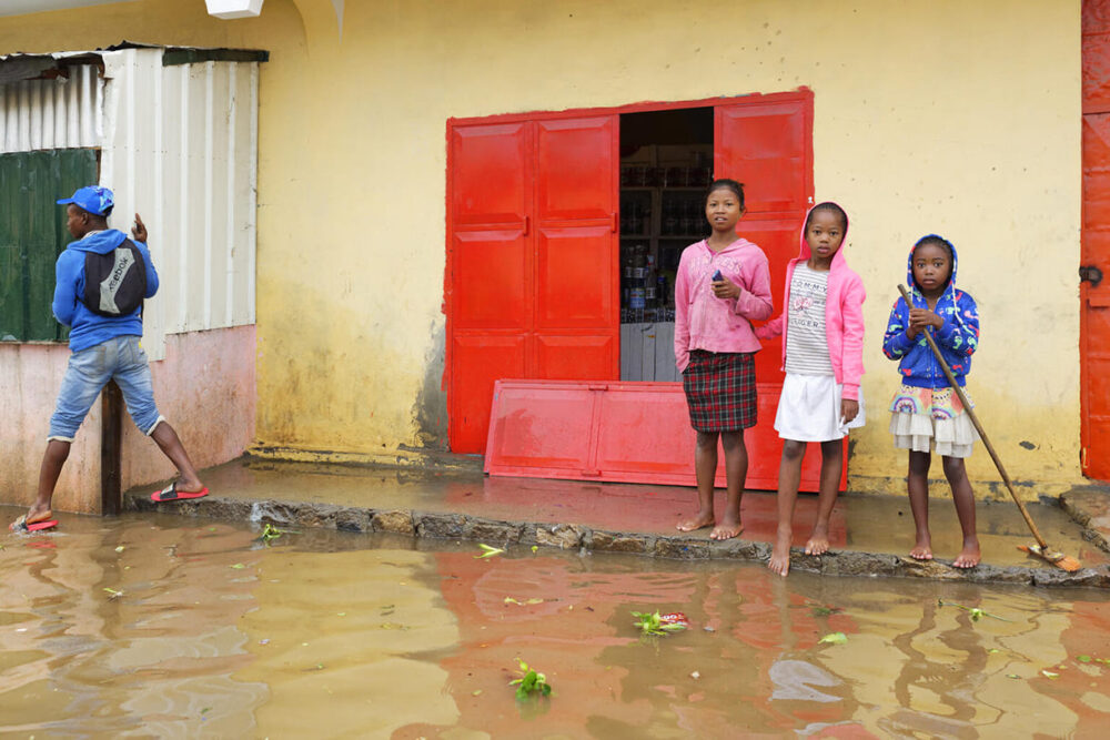 Am 19. Januar 2022 bahnen sich Menschen im Distrikt Ilanivato, Antananarivo, Region Analamanga in Madagaskar, ihren Weg durch überschwemmte Straßen.