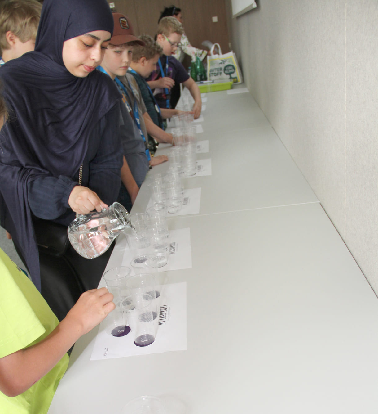 Eine Mitarbeiterin schenkt Leitungswasser ein - für die (Mineral-)Wasser-Tester:innen