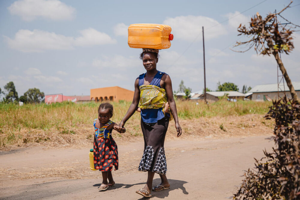 „Es ist ungefähr 3 Monate her, seit wir das Standrohr bekommen haben. Früher mussten wir Wasser aus einem Fluss holen, der 3 Kilometer von hier entfernt ist. Heute gibt es Wasser nur zwei Minuten vom Haus entfernt“, sagt Chantale Akelo, die am 1. Februar 2023 das Wasser trägt, das sie aus dem von UNICEF installierten Wasserhahn der Mbunya Primary School in Lengabo, Provinz Ituri, DR Kongo, gezapft hat.