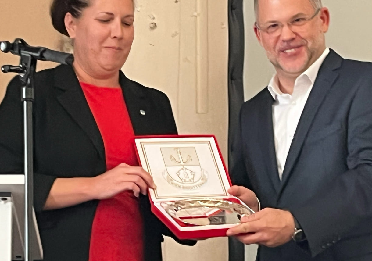 Bezirksvorsteherin Christine Dubravac-Widholm übergibt einen Brigittenauer Zinnteller an Schuldirektor Árpád Krämer